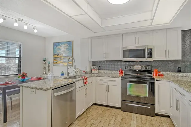 a bathroom with a granite countertop sink and a window