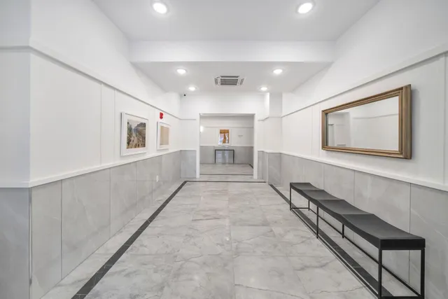 a view of a hallway to a room with view of a bathroom