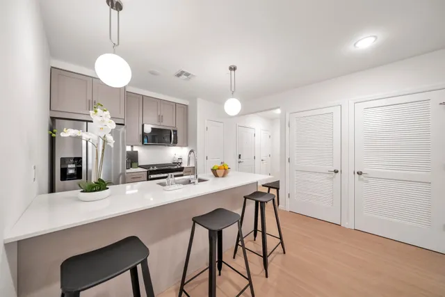 a kitchen with stainless steel appliances a dining table chairs stove and refrigerator