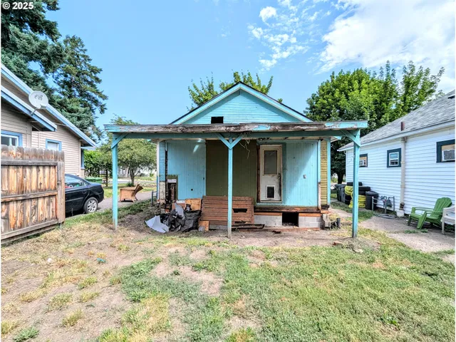 a view of a chair and table in backyard of the house