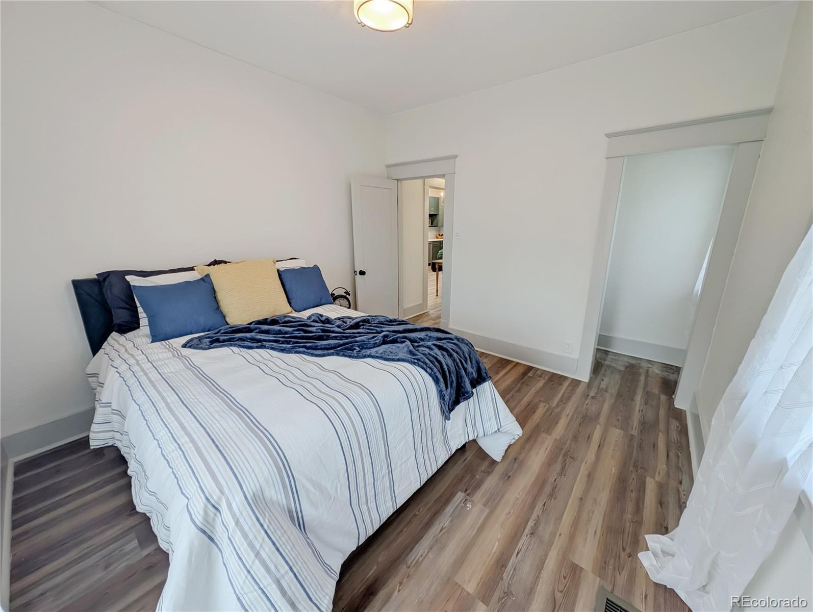 710 Carson Street Brush, CO 80723 - Photo 12 of 30 a bedroom with a bed and wooden floor