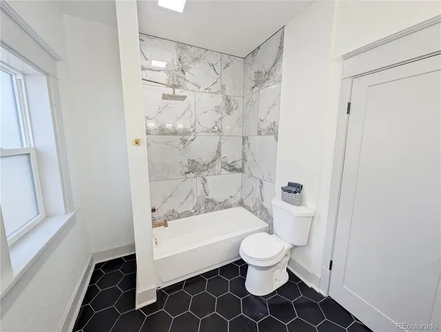 a bathroom with a toilet and a shower