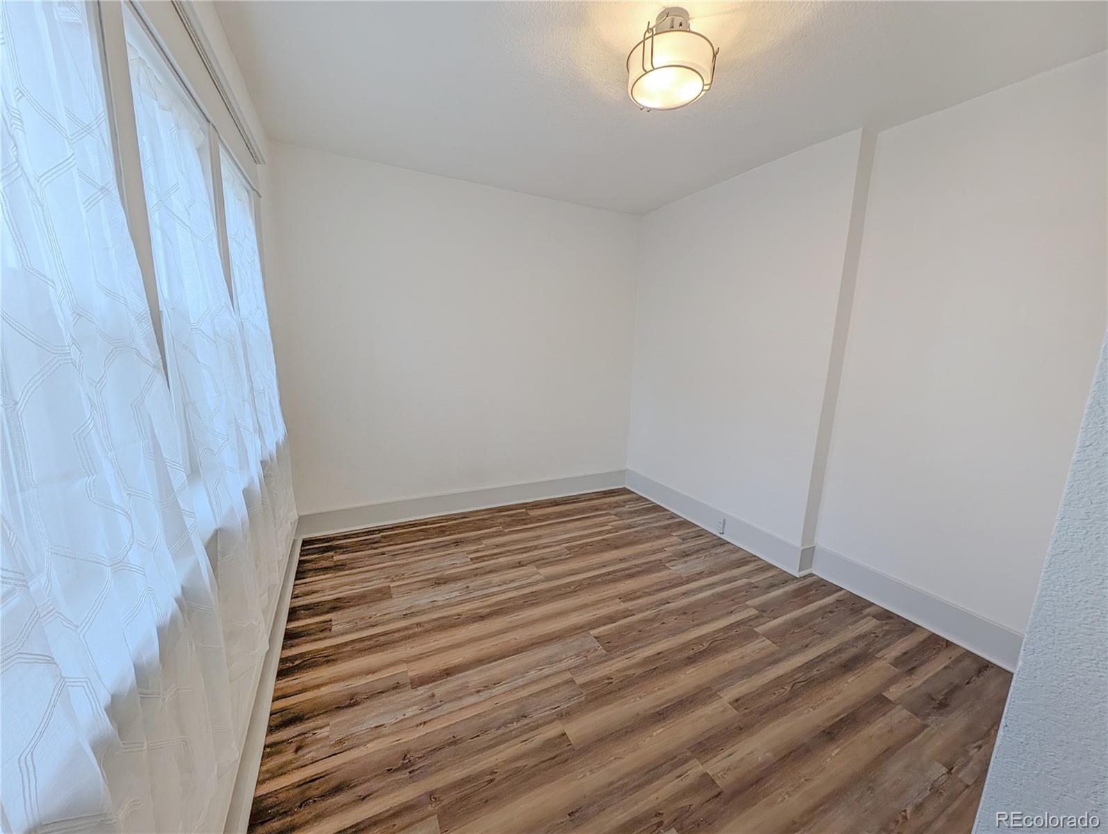 710 Carson Street Brush, CO 80723 - Photo 17 of 30 a view of a room with wooden floor and white walls