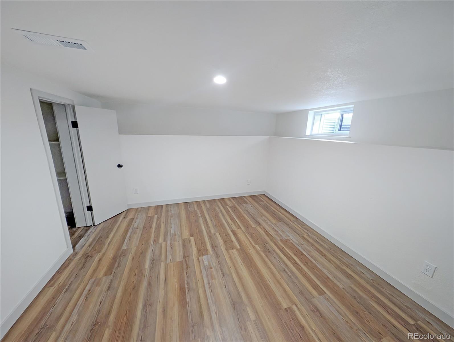 710 Carson Street Brush, CO 80723 - Photo 22 of 30 an empty room with wooden floor and entrance