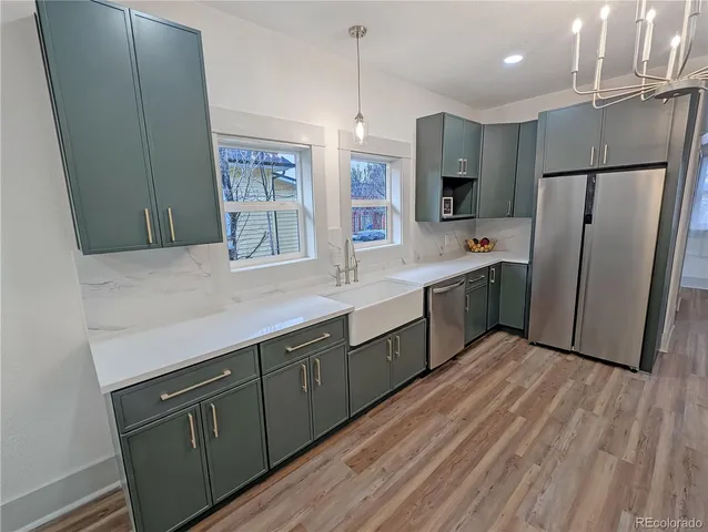 a kitchen with stainless steel appliances a sink cabinets and wooden floor