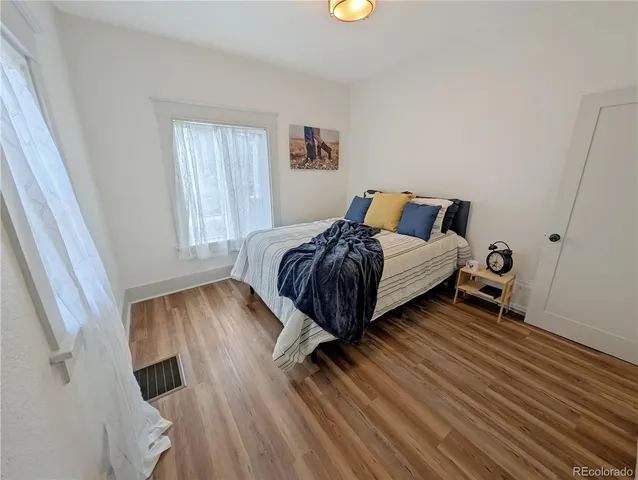 a bedroom with a bed and wooden floor