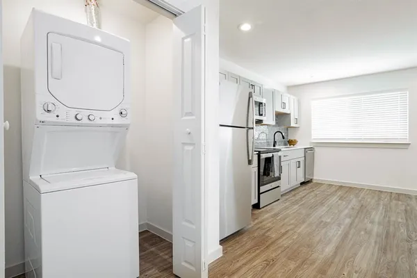 a kitchen with white cabinets and stainless steel appliances