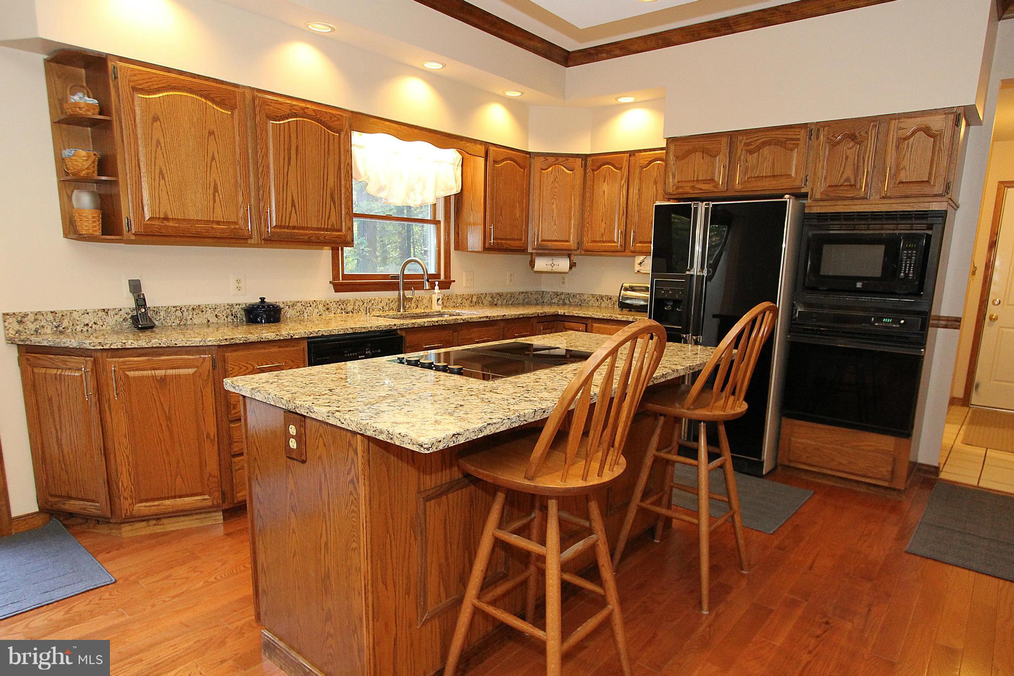 3154 Charles Street Fallston, MD 21047 - Photo 4 of 30 a kitchen with stainless steel appliances kitchen island granite countertop a table chairs in it and a microwave