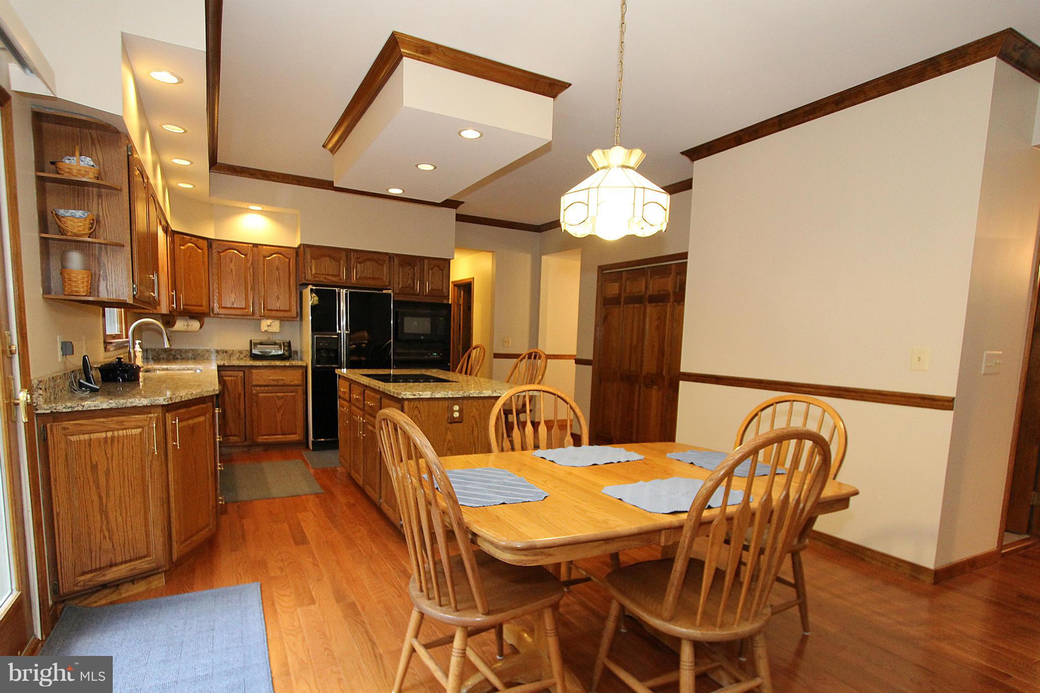 3154 Charles Street Fallston, MD 21047 - Photo 5 of 30 a dining room with stainless steel appliances kitchen island granite countertop a table chairs and a refrigerator