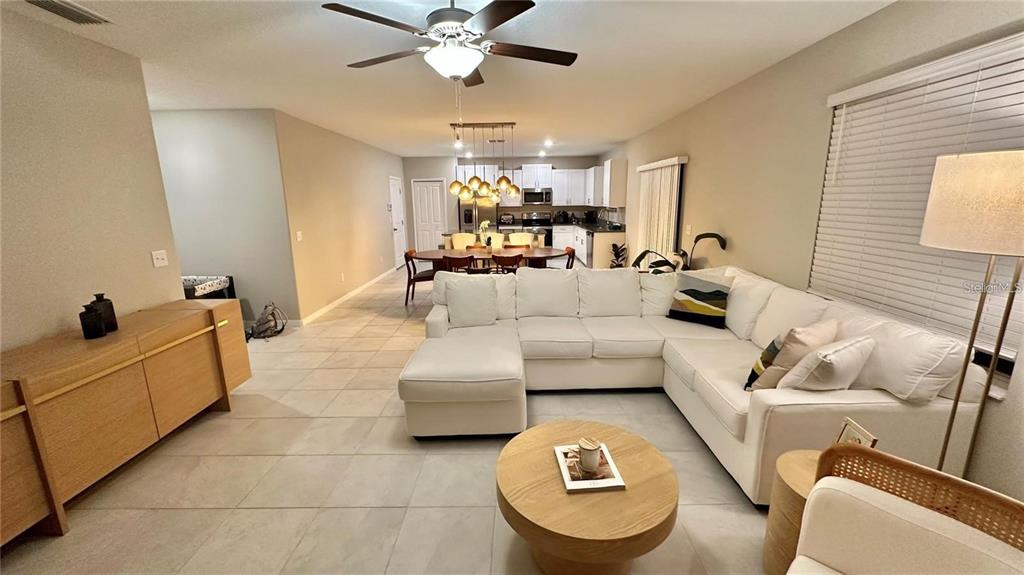 31363 Sun Kettle Loop Wesley Chapel, FL 33545 - Photo 13 of 29 a living room with furniture and a chandelier