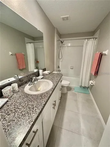a bathroom with a granite countertop sink a mirror and a bathtub