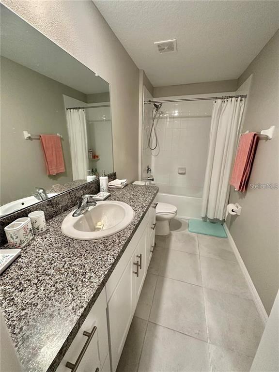 31363 Sun Kettle Loop Wesley Chapel, FL 33545 - Photo 21 of 29 a bathroom with a granite countertop sink a mirror and a bathtub