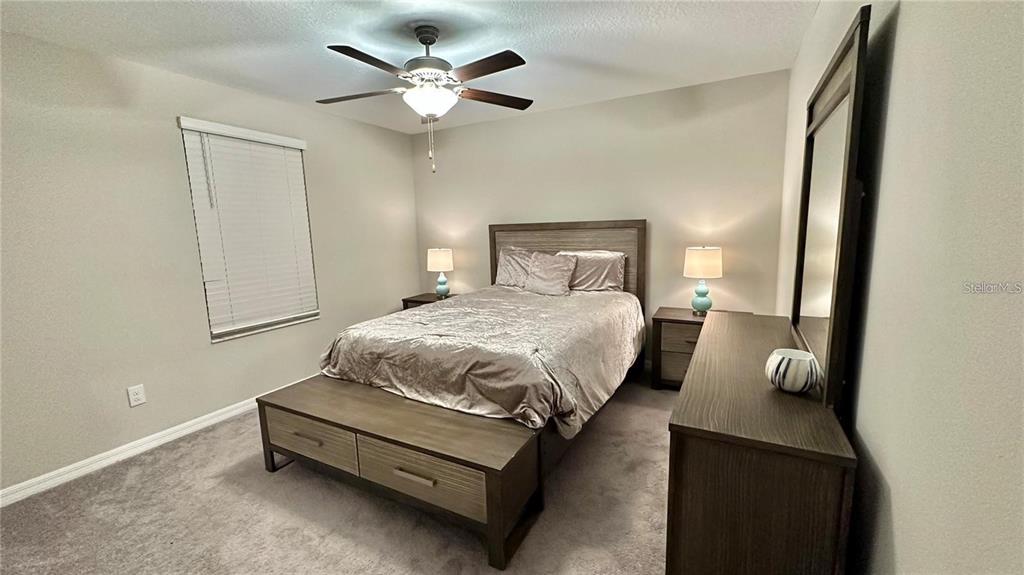 31363 Sun Kettle Loop Wesley Chapel, FL 33545 - Photo 24 of 29 a bedroom with a bed and a chandelier