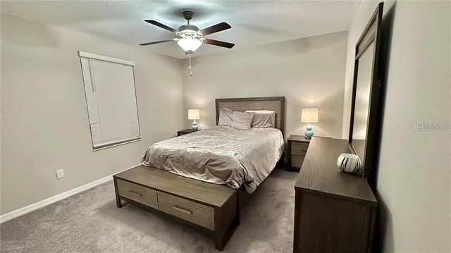 a spacious bedroom with a bed and a chandelier