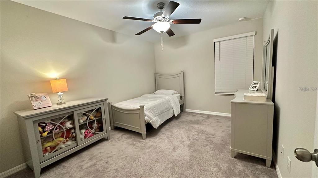 31363 Sun Kettle Loop Wesley Chapel, FL 33545 - Photo 28 of 29 a bedroom with a bed and a chandelier