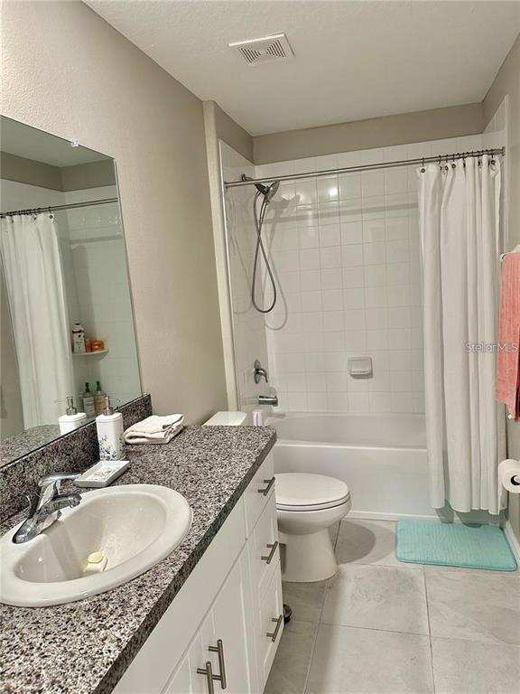 31363 Sun Kettle Loop Wesley Chapel, FL 33545 - Photo 29 of 29 a bathroom with a granite countertop sink a toilet a mirror a bathtub and shower