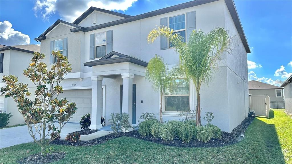31363 Sun Kettle Loop Wesley Chapel, FL 33545 - Photo 3 of 29 a front view of a house with garden