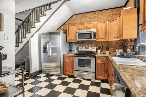 a kitchen with stainless steel appliances granite countertop a stove a sink and a refrigerator