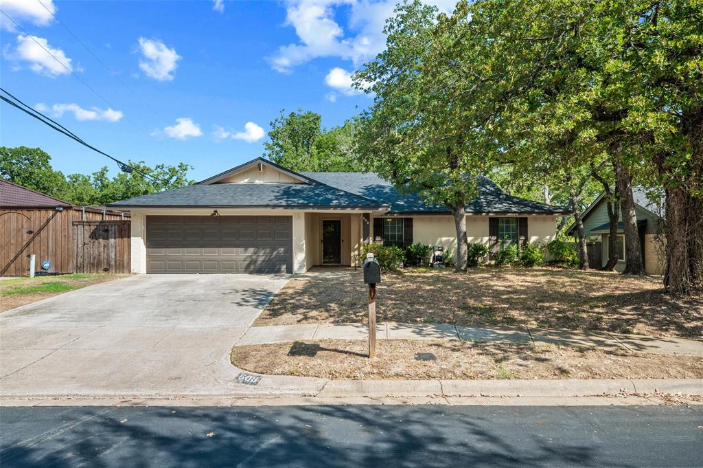 608 Ridgewood Circle Hurst, TX 76054 - Photo 5 of 38 Single-story residence featuring a two-car garage, front yard landscaping, and mature trees