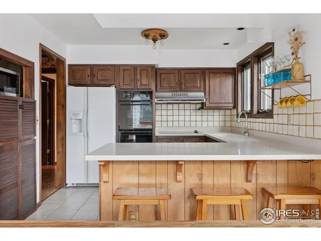a kitchen with kitchen island granite countertop a refrigerator and a sink