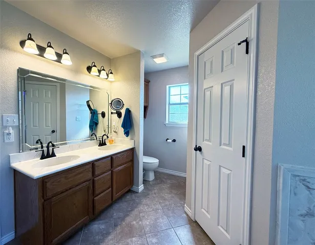 a spacious bathroom with a double vanity sink and a mirror