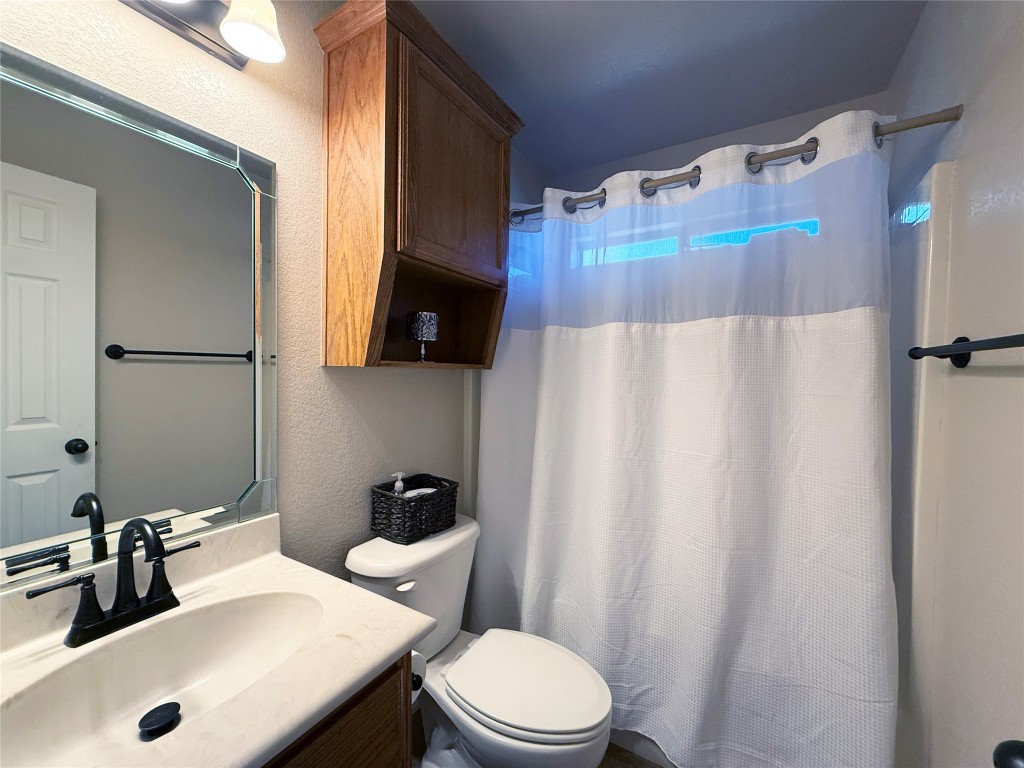 1502 Hamilton Street Burnet, TX 78611 - Photo 20 of 26 a bathroom with a sink a toilet and shower curtain