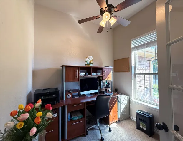a view of a workspace with furniture and a window