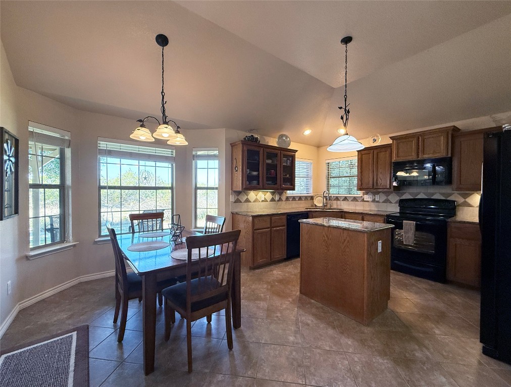 1502 Hamilton Street Burnet, TX 78611 - Photo 8 of 26 a kitchen with stainless steel appliances granite countertop a refrigerator a stove a kitchen island a dining table and chairs