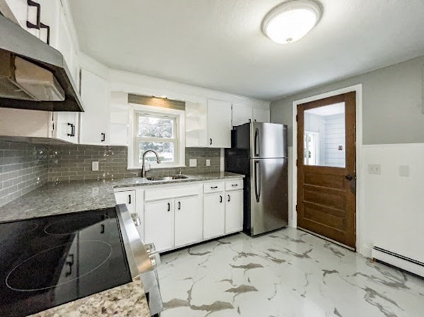 47 Bourbeau Street Chicopee, MA 01020 - Photo 3 of 19 a kitchen with granite countertop a refrigerator a sink a stove a microwave a counter top and oven