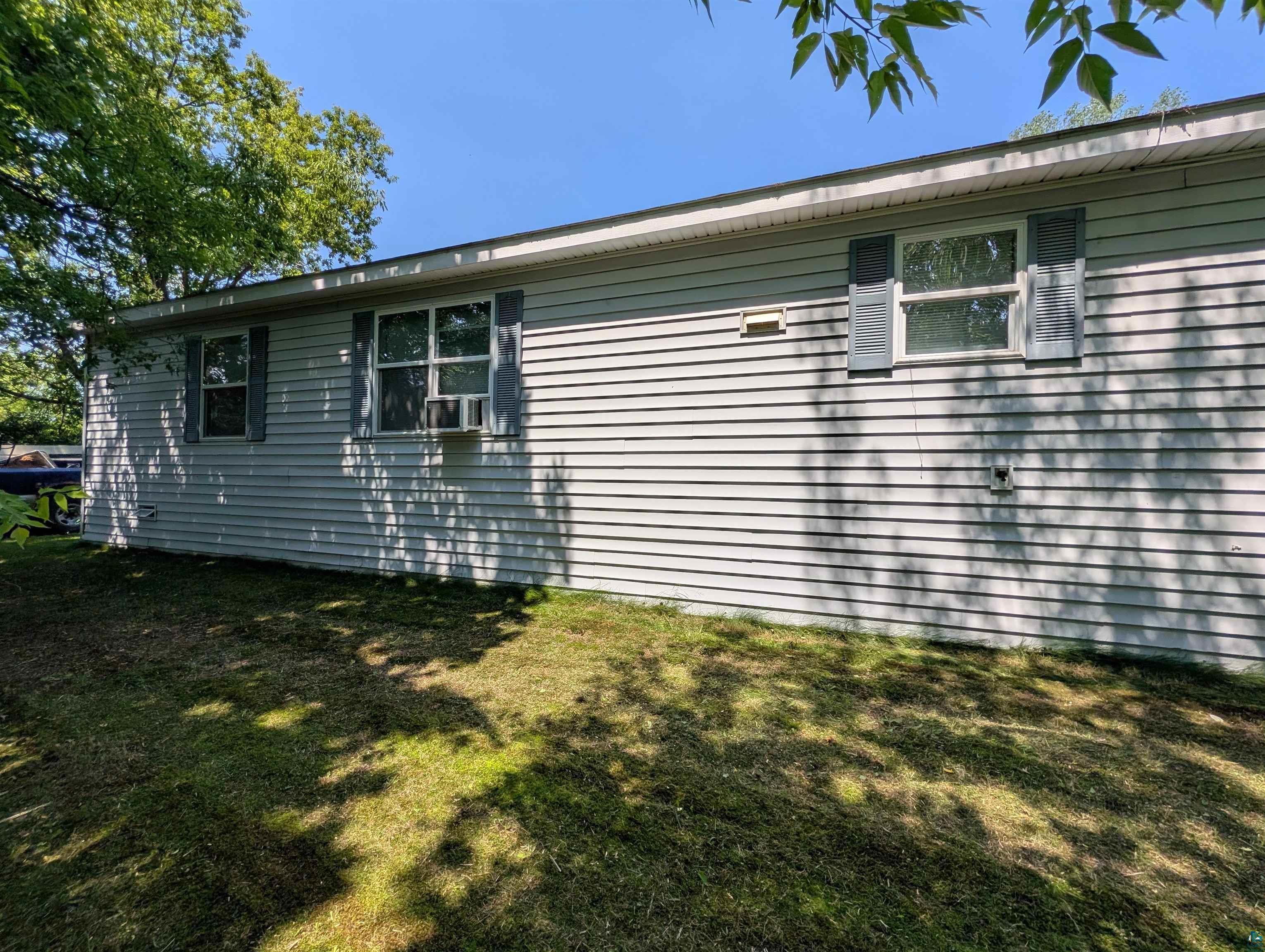 3945 Maple Street Kettle River, MN 55757 - Photo 40 of 41 Light-colored siding exterior featuring multiple windows with dark shutters