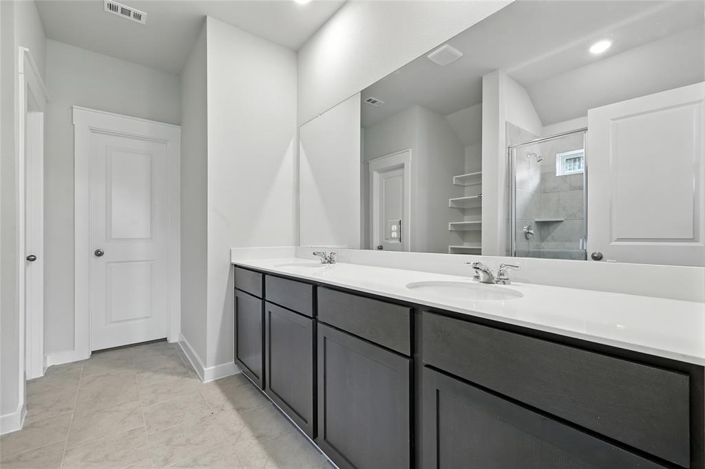 604 Martell Road Princeton, TX 75407 - Photo 20 of 38 a bathroom with a double vanity sink and a mirror