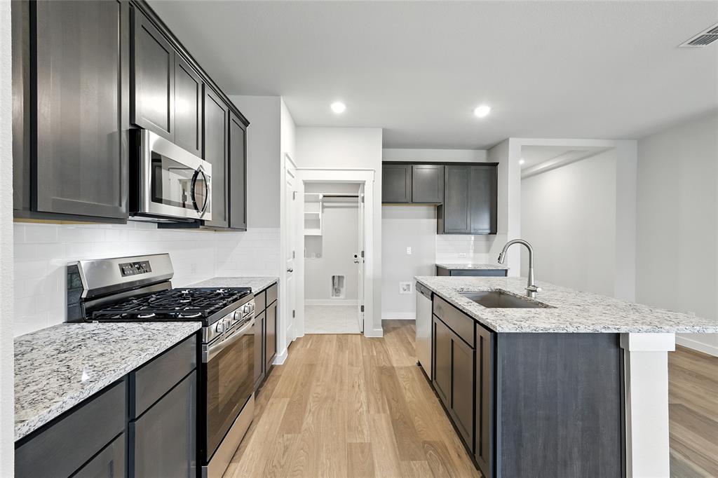 604 Martell Road Princeton, TX 75407 - Photo 4 of 38 a kitchen with stainless steel appliances granite countertop a sink stove and refrigerator