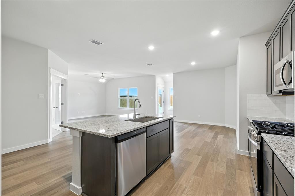 604 Martell Road Princeton, TX 75407 - Photo 6 of 38 a kitchen with a sink stove and cabinets