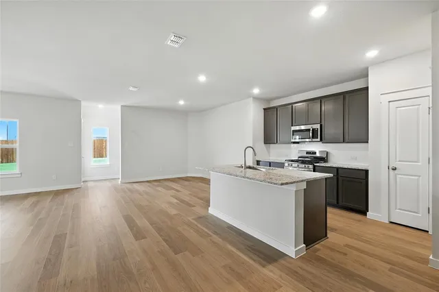 a kitchen with stainless steel appliances granite countertop a sink stove and refrigerator