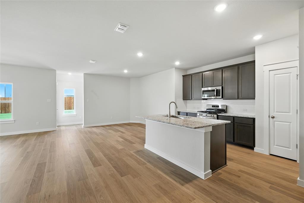 604 Martell Road Princeton, TX 75407 - Photo 7 of 38 a kitchen with stainless steel appliances granite countertop a sink stove and refrigerator