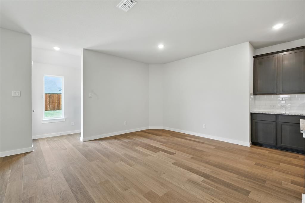 604 Martell Road Princeton, TX 75407 - Photo 8 of 38 a view of an empty room with wooden floor and a window
