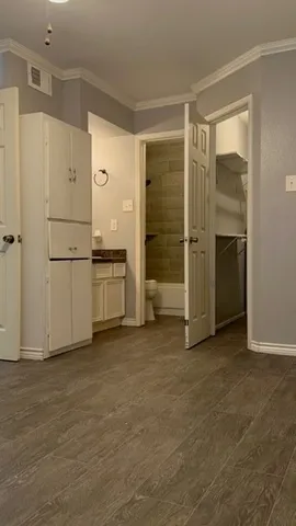 a view of a kitchen with refrigerator and white cabinets