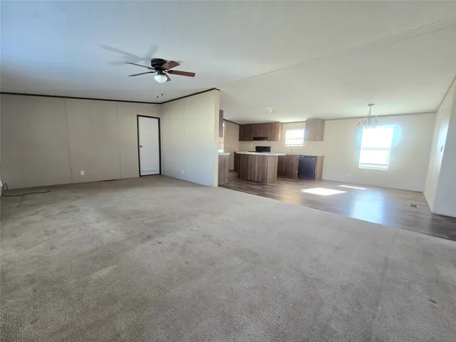 an empty room with windows and cabinet