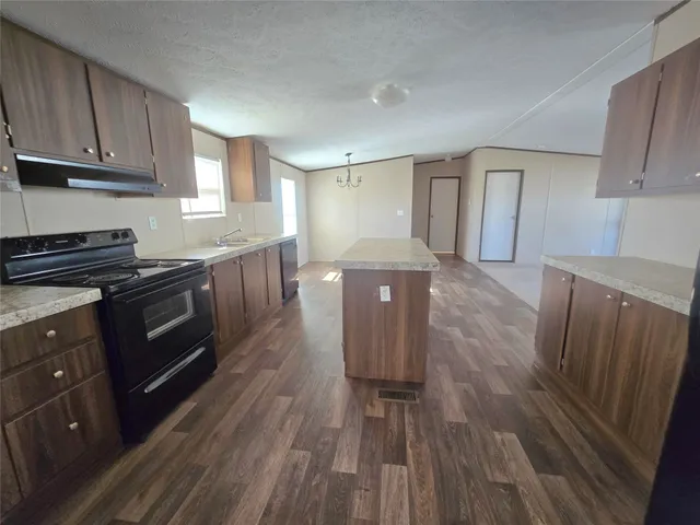a kitchen with wooden floors and wooden cabinets