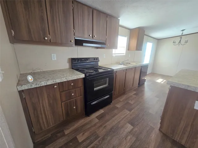 a kitchen with stainless steel appliances granite countertop wooden cabinets a sink and dishwasher