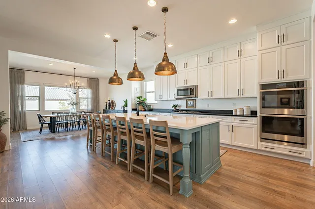 a large kitchen with stainless steel appliances kitchen island granite countertop a sink counter space and a view of living room