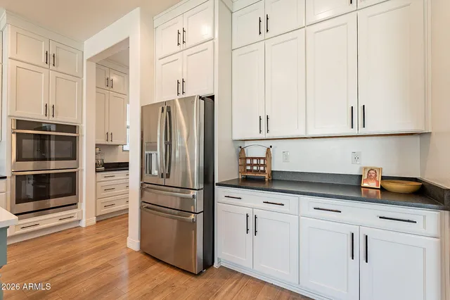 a kitchen with stainless steel appliances granite countertop a sink a stove and a refrigerator