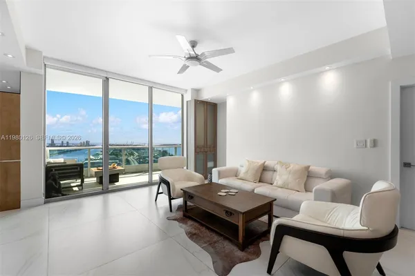 a living room with furniture and a floor to ceiling window