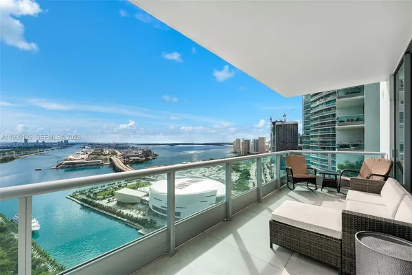 a balcony with couple of chairs and sink