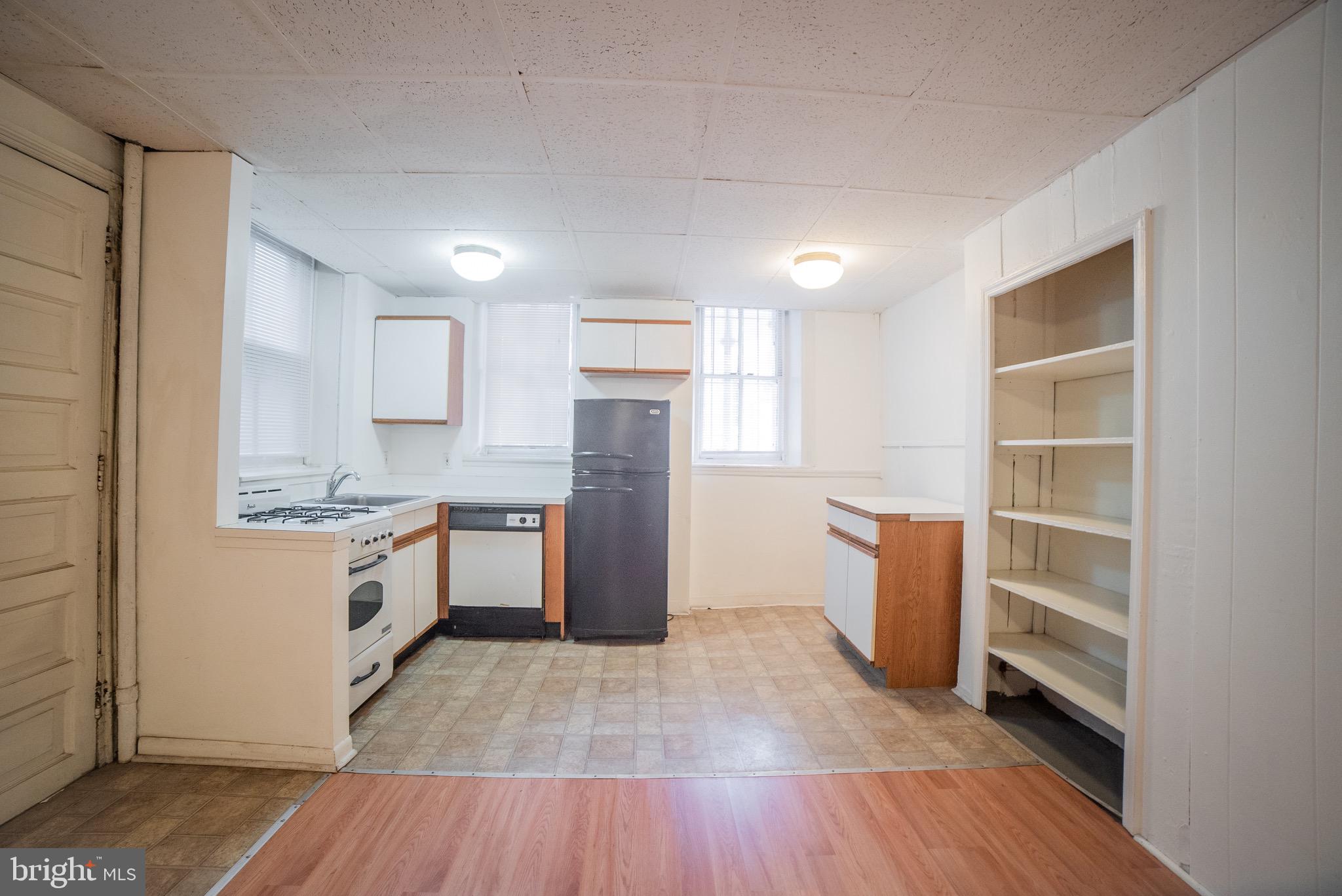 2116 Walnut Street Philadelphia, PA 19103 - Photo 5 of 12 a kitchen with granite countertop a refrigerator and a stove top oven