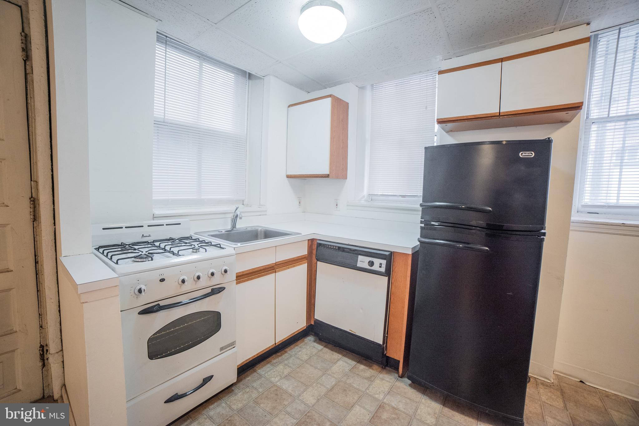 2116 Walnut Street Philadelphia, PA 19103 - Photo 6 of 12 a kitchen with granite countertop a refrigerator stove and sink