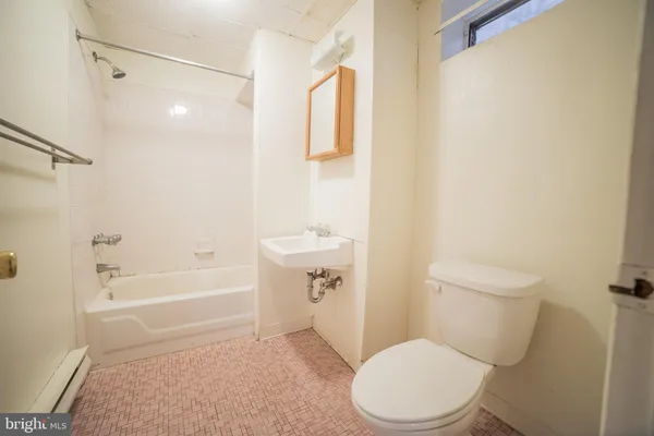 a white toilet sitting next to a bath tub and a shower
