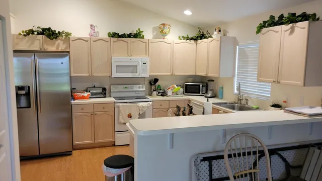 a kitchen with stainless steel appliances a table chairs and a refrigerator
