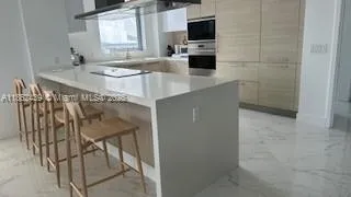 a kitchen with stainless steel appliances a stove a microwave and a sink