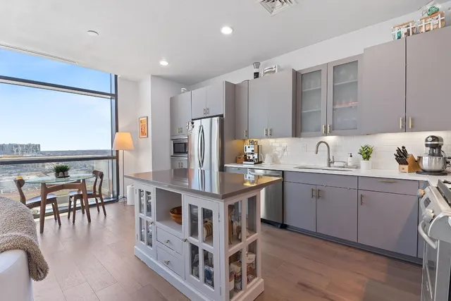 a dining room with furniture and a floor to ceiling window